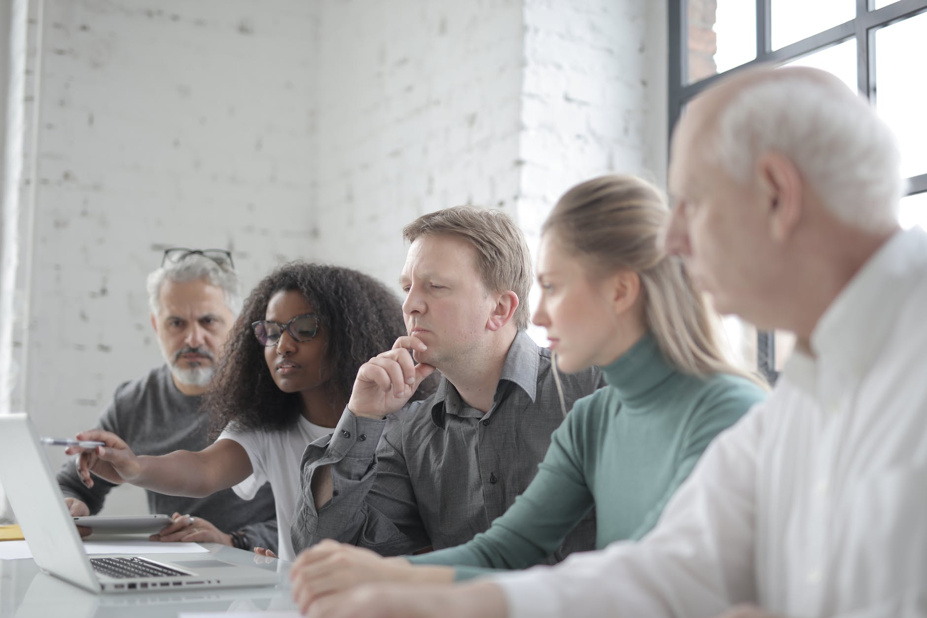 multiracial partners watching laptop screen at work conference